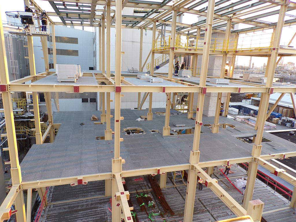 Blick durch die Stahlkonstruktion eines Produktionsgebäudes mit Fachwerkträgern.